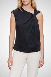 Woman wearing a black sleeveless top with a knot detail on a white background