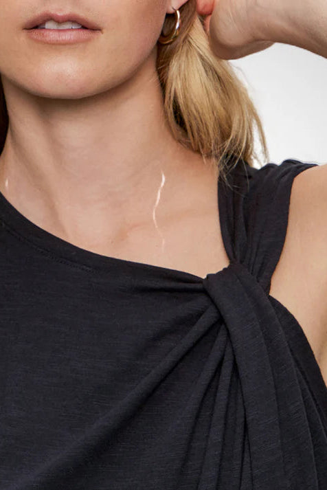 Close-up of a person wearing a black sleeveless top with a white background