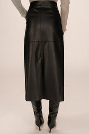 Back view of a person wearing a black leather skirt and black boots