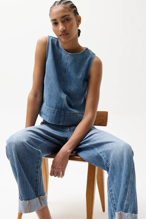 Woman wearing light wash straight-leg jeans with a cuffed hem