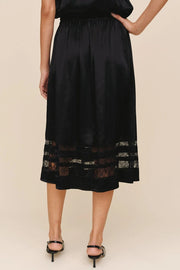 woman wearing a black a-line inset lace midi skirt