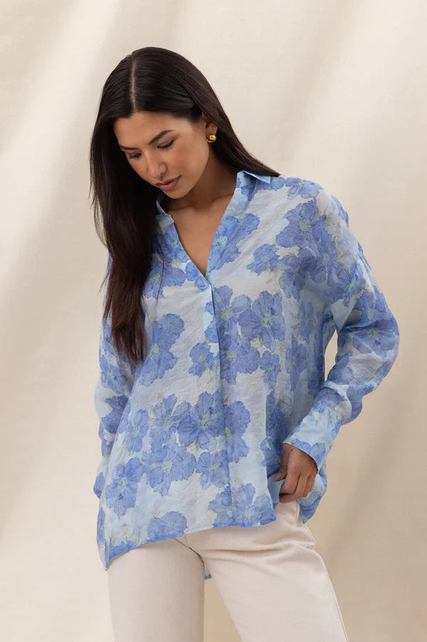 Woman wearing a blue floral long-sleeve button-up blouse with a relaxed fit, front