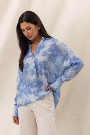 Woman wearing a blue floral long-sleeve button-up blouse with a relaxed fit, front