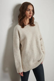 Front view of woman wearing an oatmeal coloured oversized knit 