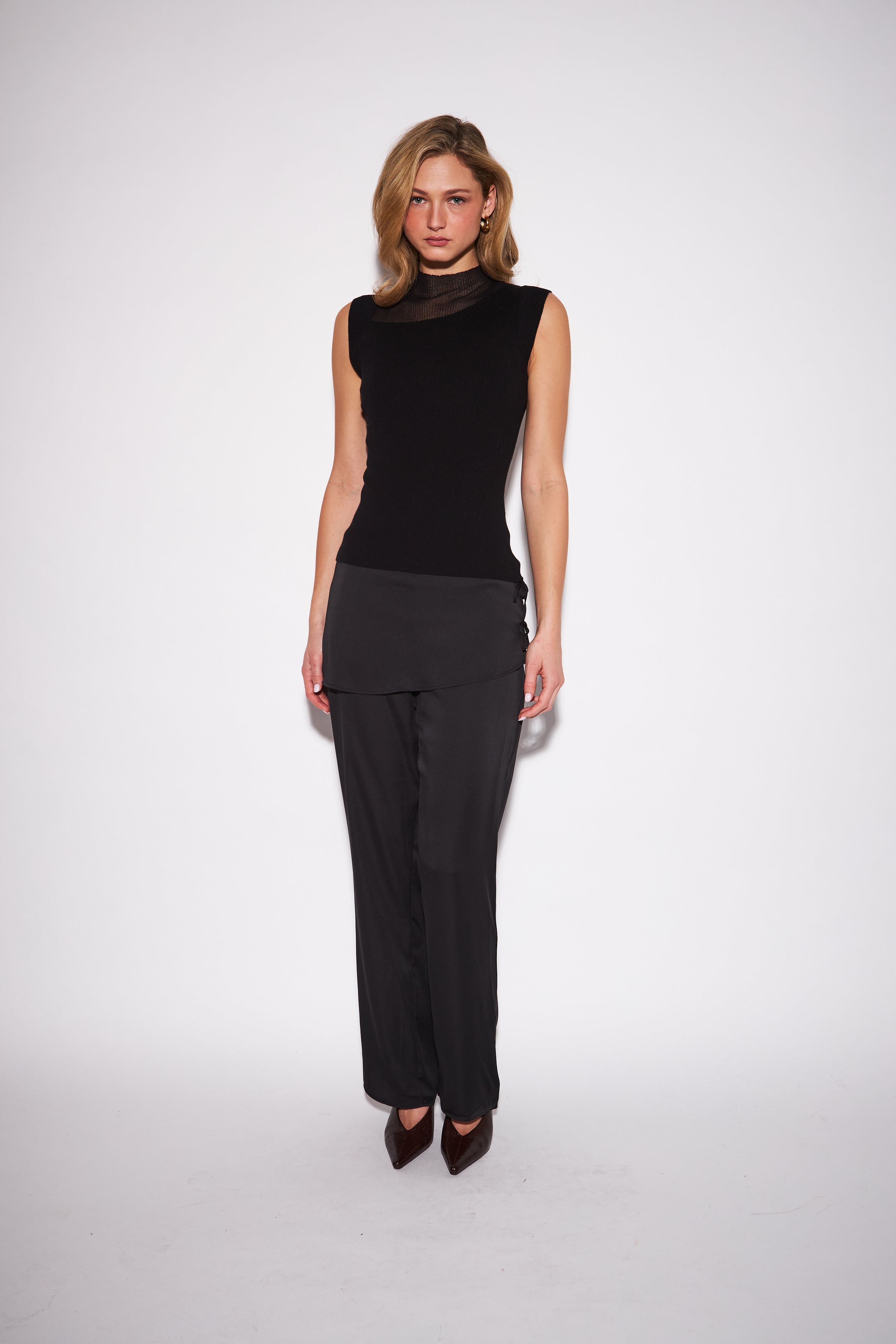 model wearing a black high neck sleeveless top with a sheer neckline 