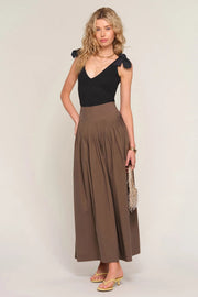 woman wearing a brown high-waisted pleated maxi skirt, front