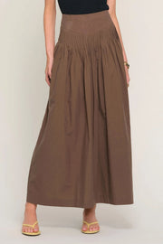 woman wearing a brown high-waisted pleated maxi skirt, front