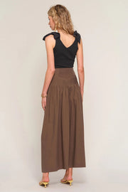 woman wearing a brown high-waisted pleated maxi skirt, back