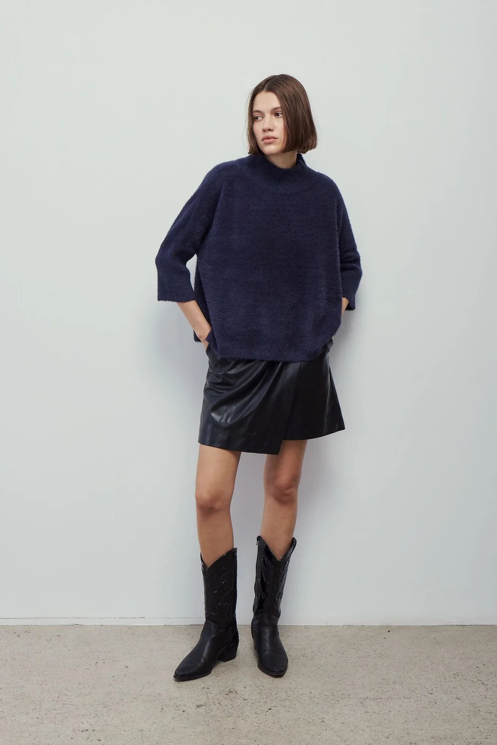 woman wearing oversized navy mock neck sweater 