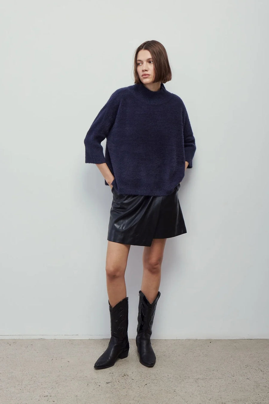 woman wearing oversized navy mock neck sweater 