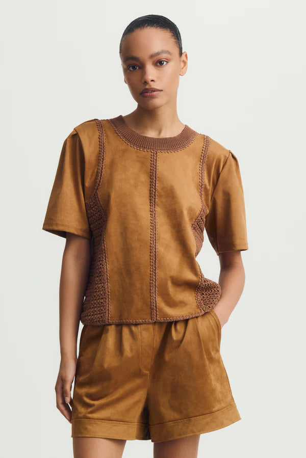 Front view of woman wearing a mixed crochet and suede leather short sleeve top
