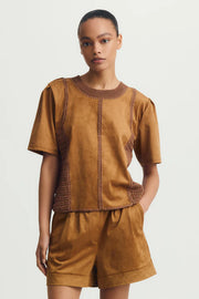 Front view of woman wearing a mixed crochet and suede leather short sleeve top