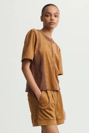 Side view of woman wearing a mixed crochet and suede leather short sleeve top