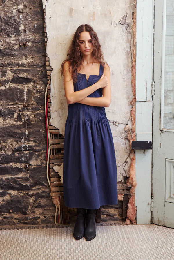 Woman in a blue dress with smocked waist. 