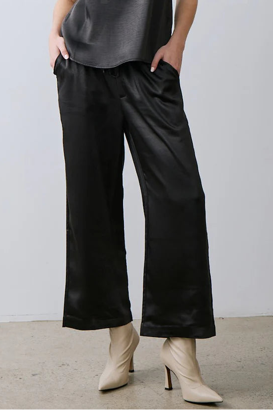 woman wearing a black draw string wide leg satin pant