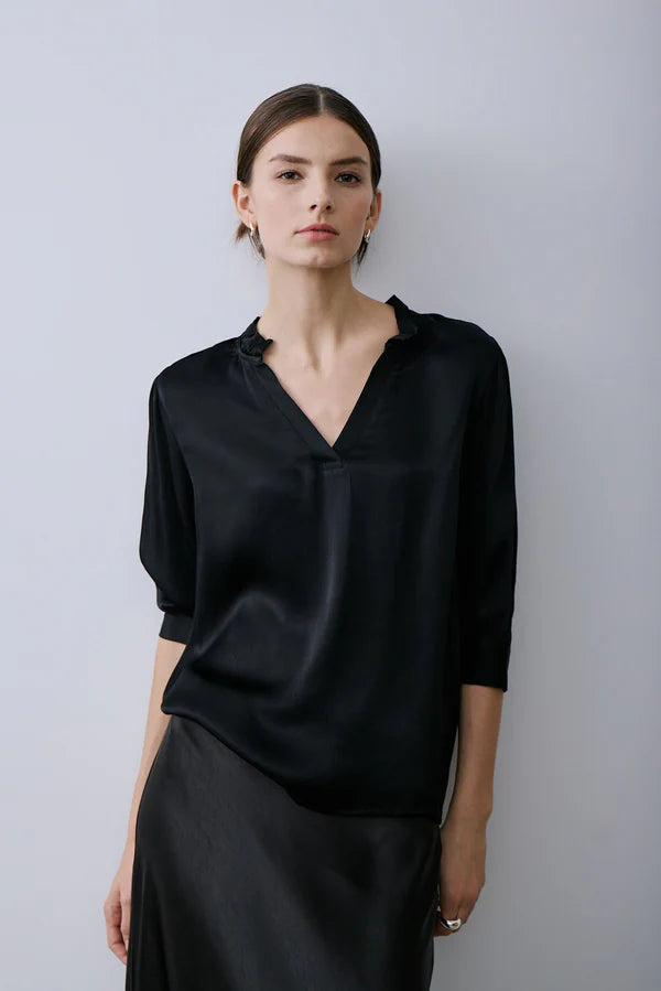 Woman wearing a black v-neck elbow sleeve blouse