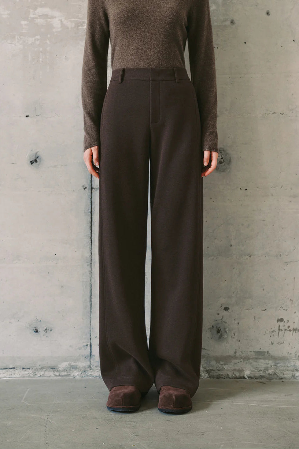 Woman wearing dark brown high-waisted wide-leg trousers, front