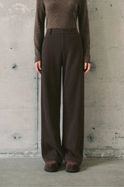 Woman wearing dark brown high-waisted wide-leg trousers, front
