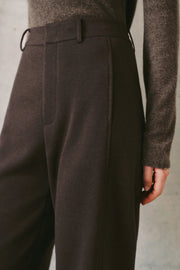 Woman wearing dark brown high-waisted wide-leg trousers, side detail