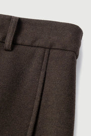 Woman wearing dark brown high-waisted wide-leg trousers, waist detail