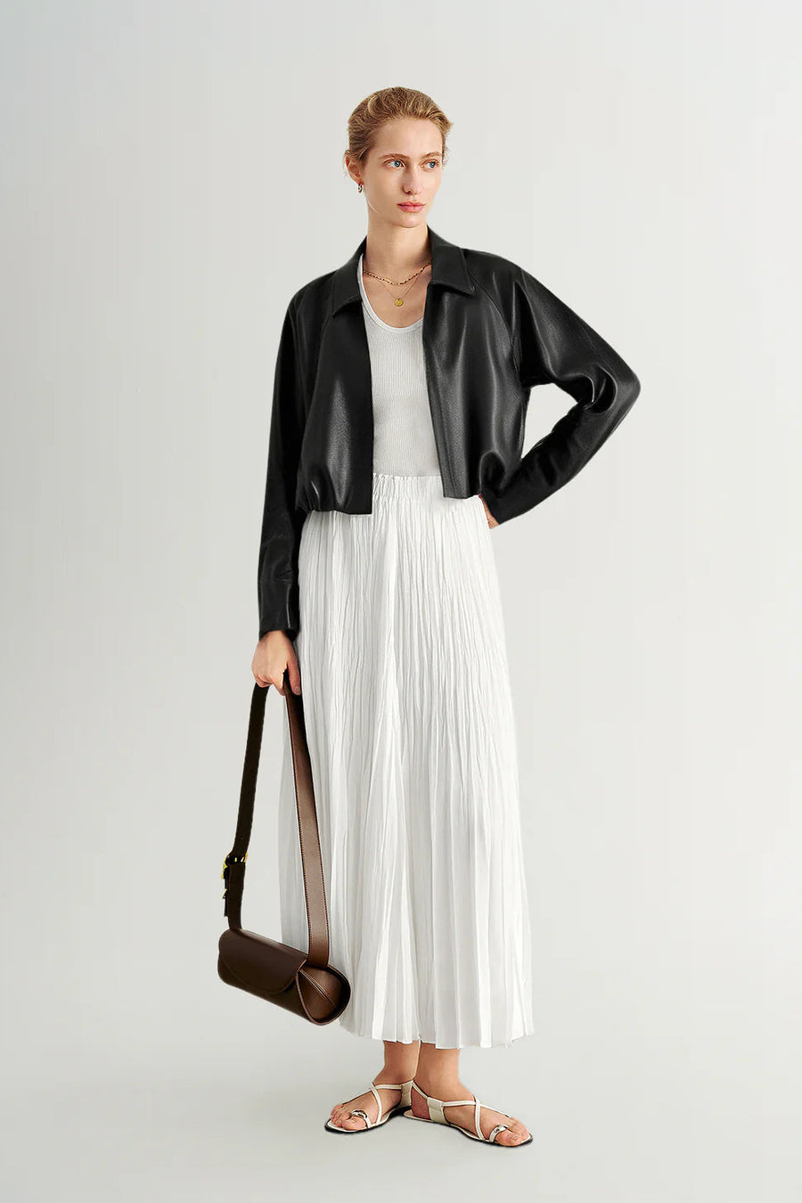 Woman wearing a black long-sleeve collared faux leather jacket, front