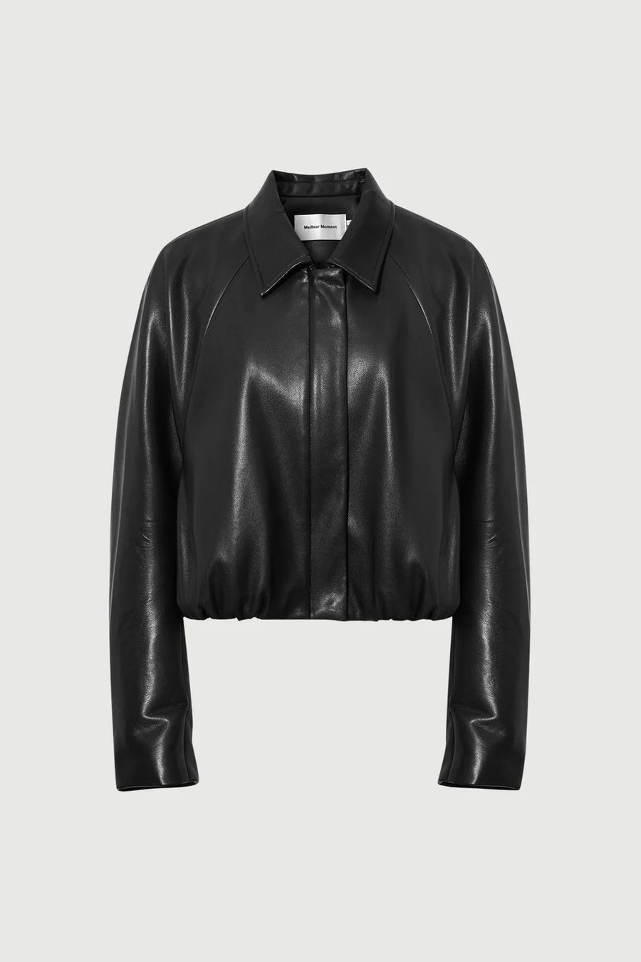 Woman wearing a black long-sleeve collared faux leather jacket, front