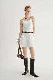 Woman wearing white tailored high-waisted shorts, full body view