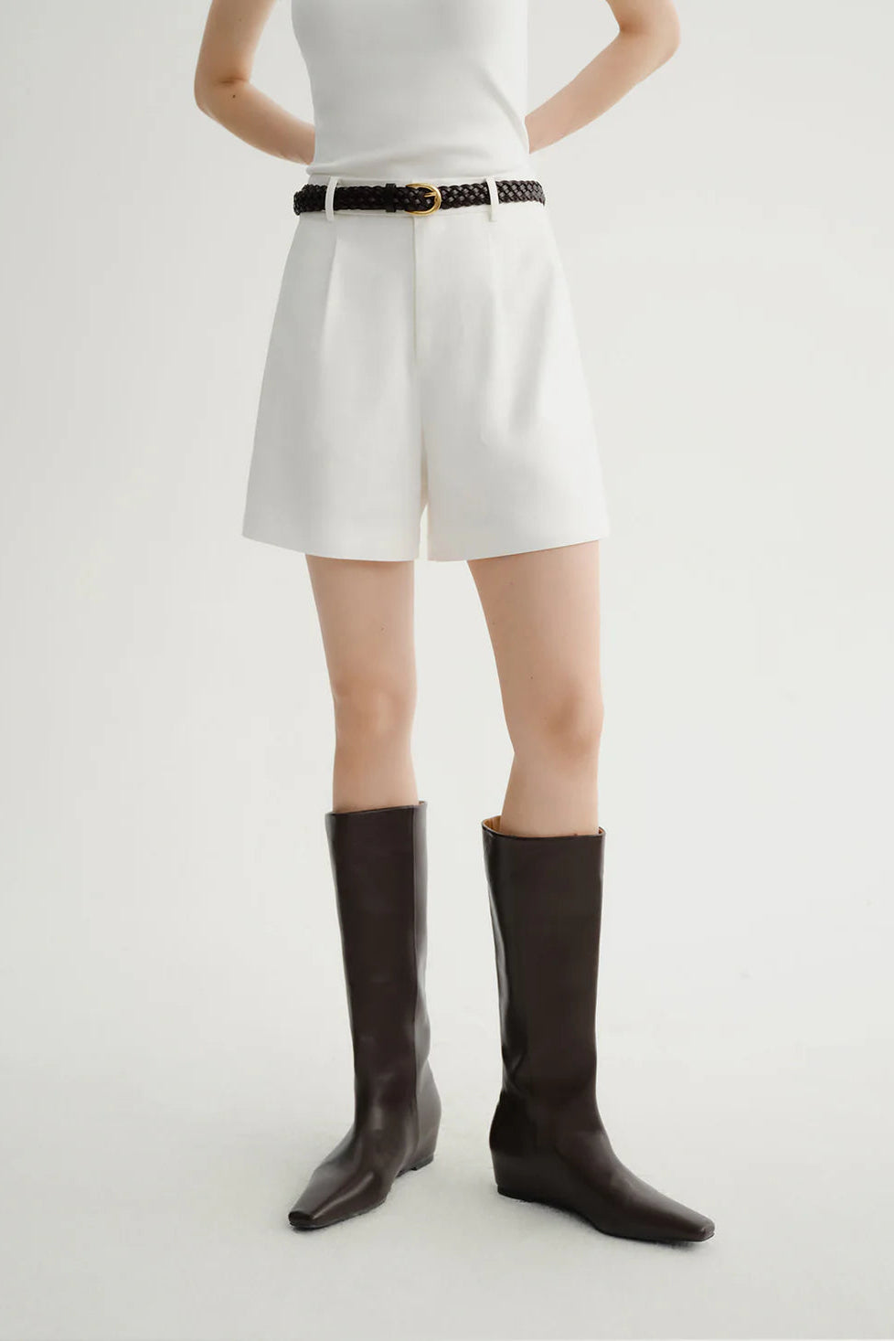 Woman wearing white tailored high-waisted shorts, front view