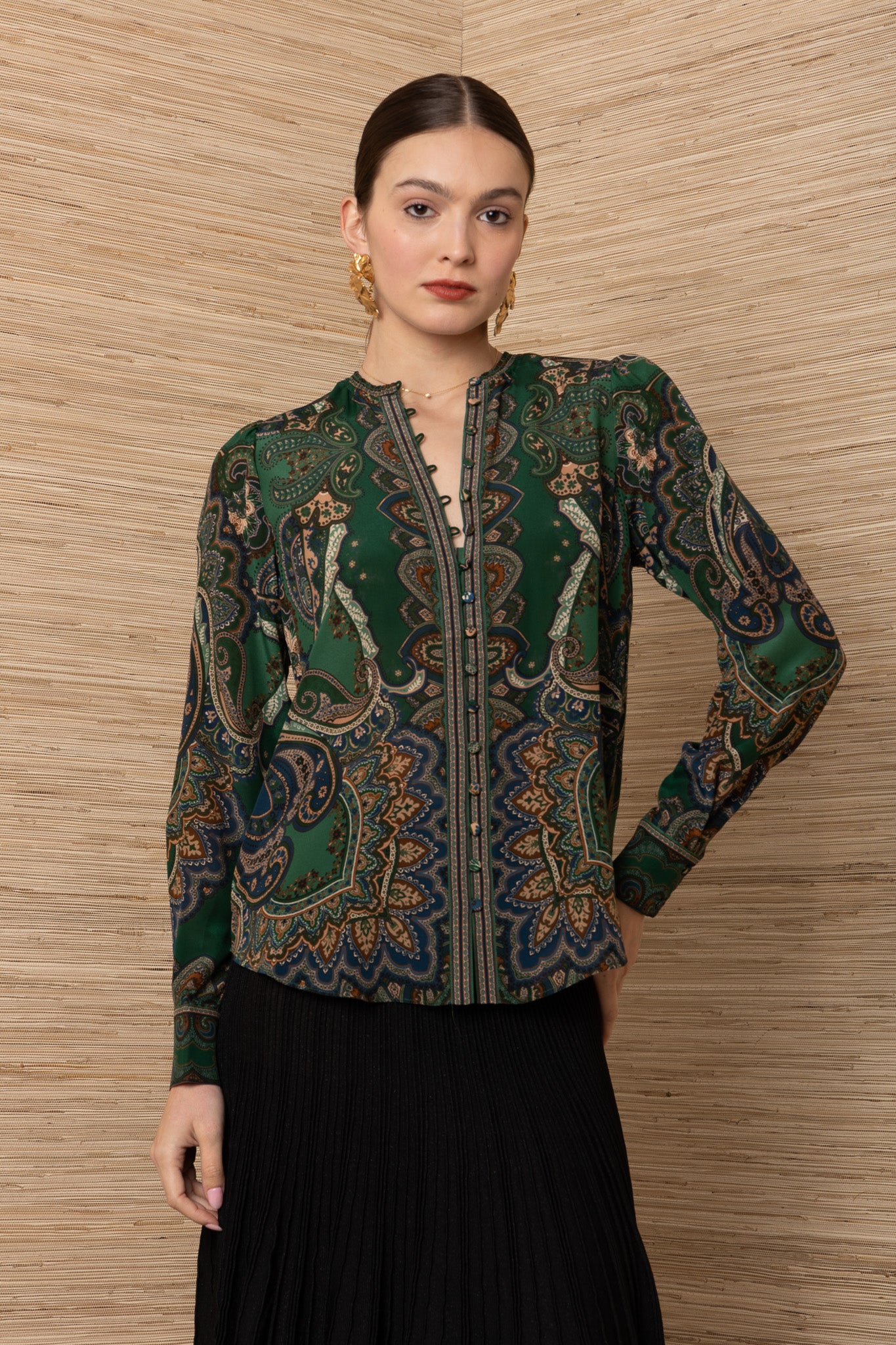 women wearing a green button up blouse with gold and blue floral designs with a structured fit 