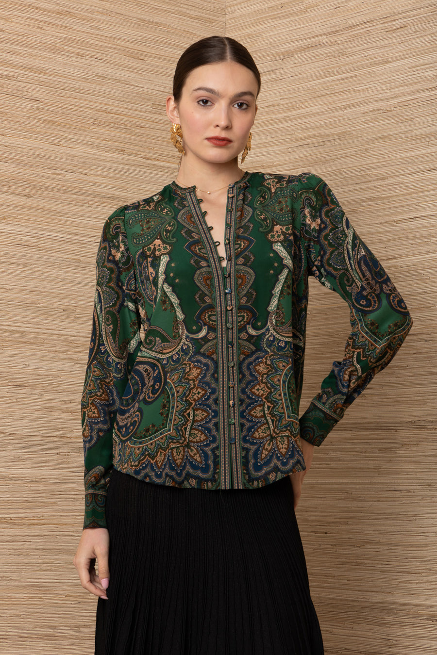 women wearing a green button up blouse with gold and blue floral designs with a structured fit 