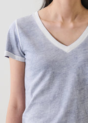 Woman wearing a blue V-neck short-sleeve T-shirt with contrast trim, detail view