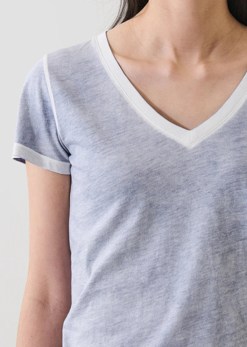 Woman wearing a blue V-neck short-sleeve T-shirt with contrast trim, detail view