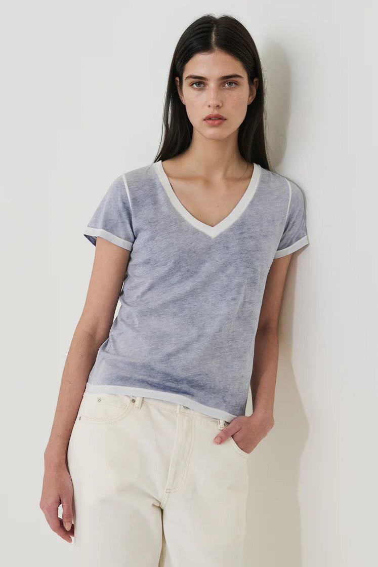 Woman wearing a blue V-neck short-sleeve T-shirt with contrast trim, front view