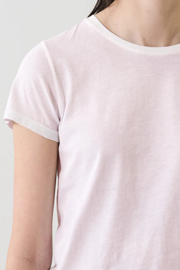 Woman wearing a light pink crewneck short-sleeve T-shirt, detail view