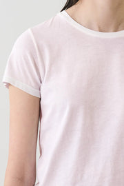 Woman wearing a light pink crewneck short-sleeve T-shirt, detail view