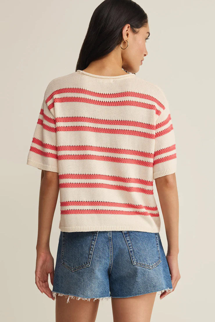 Woman wearing a cream short-sleeve knit top with red horizontal stripes, back
