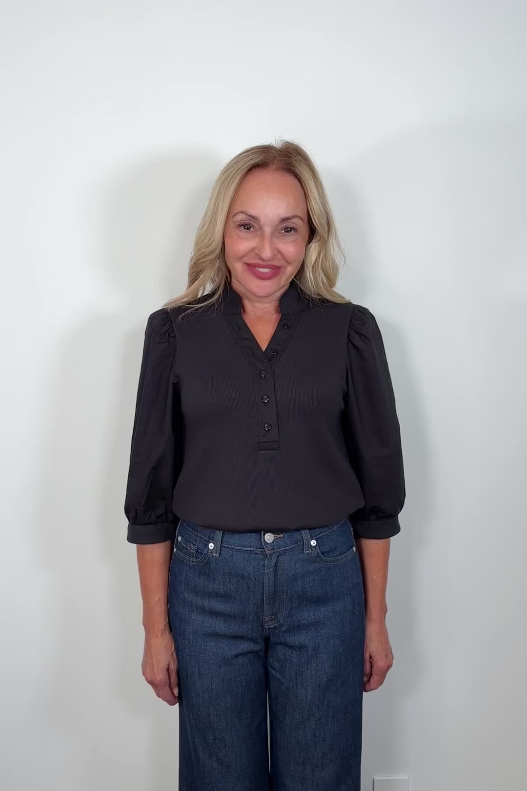 Video of a woman wearing a half sleeve black top