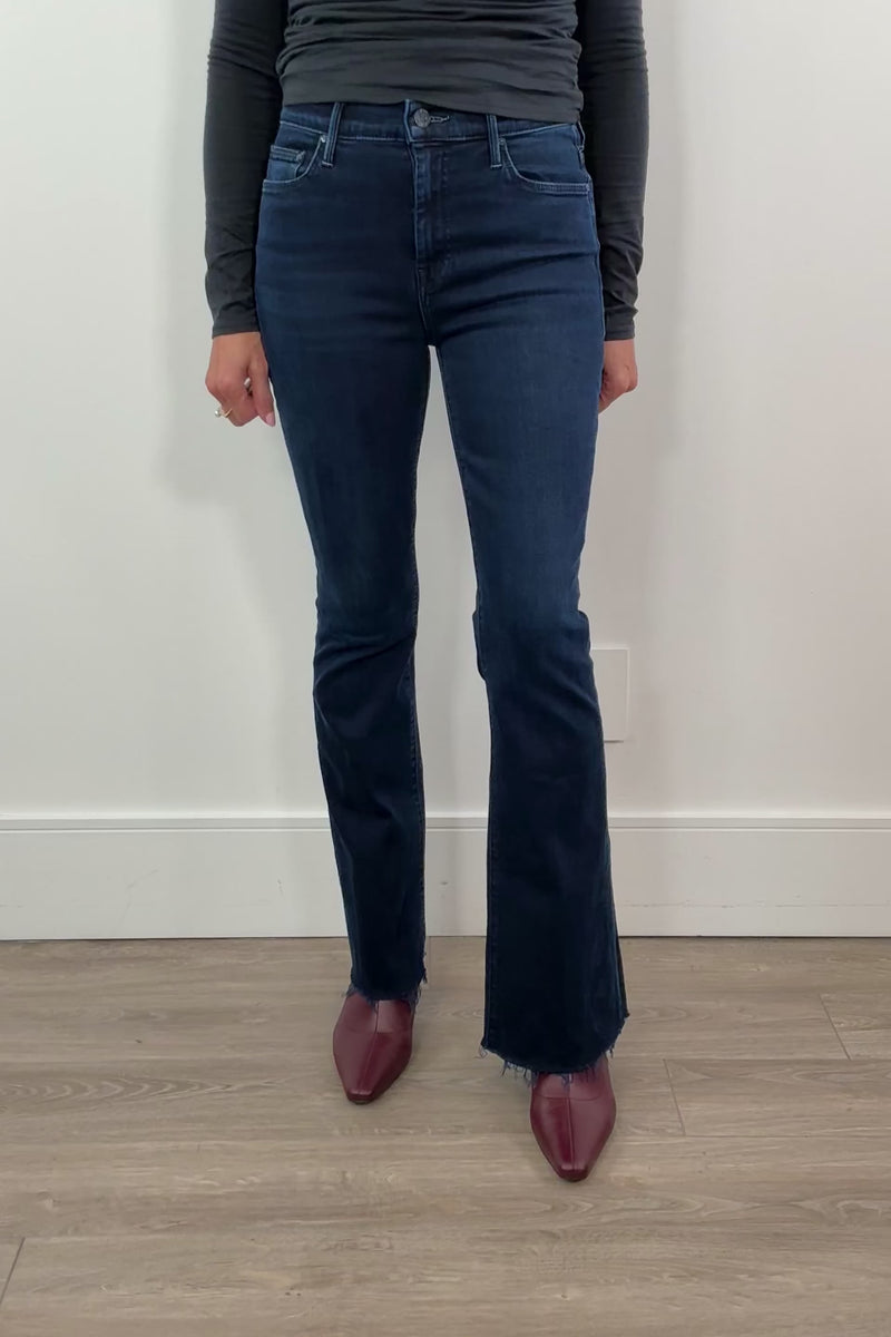 video of a woman wearing frayed dark blue jeans 