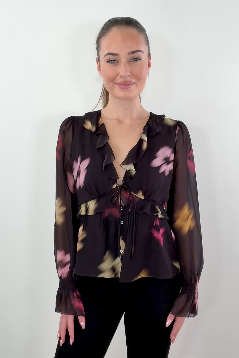 video of woman wearing a chiffon blouse with floral graphic allover