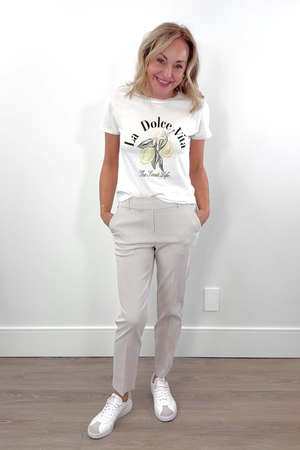 Video of woman wearing an ankle length beige stripped pants