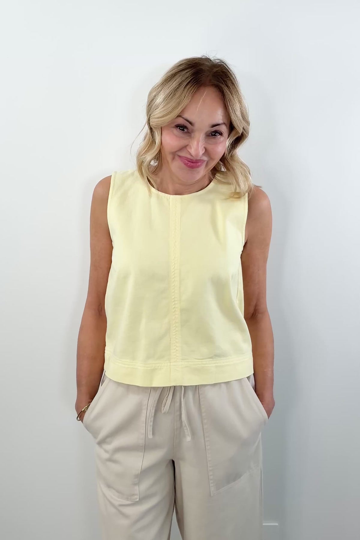 video of woman wearing a light yellow twill tank top with a back 1/4 zipper