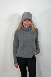 Video of a woman wearing a gray long sleeve turtle neck sweater