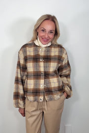 Video of a woman wearing a brown plaided bomber jacket