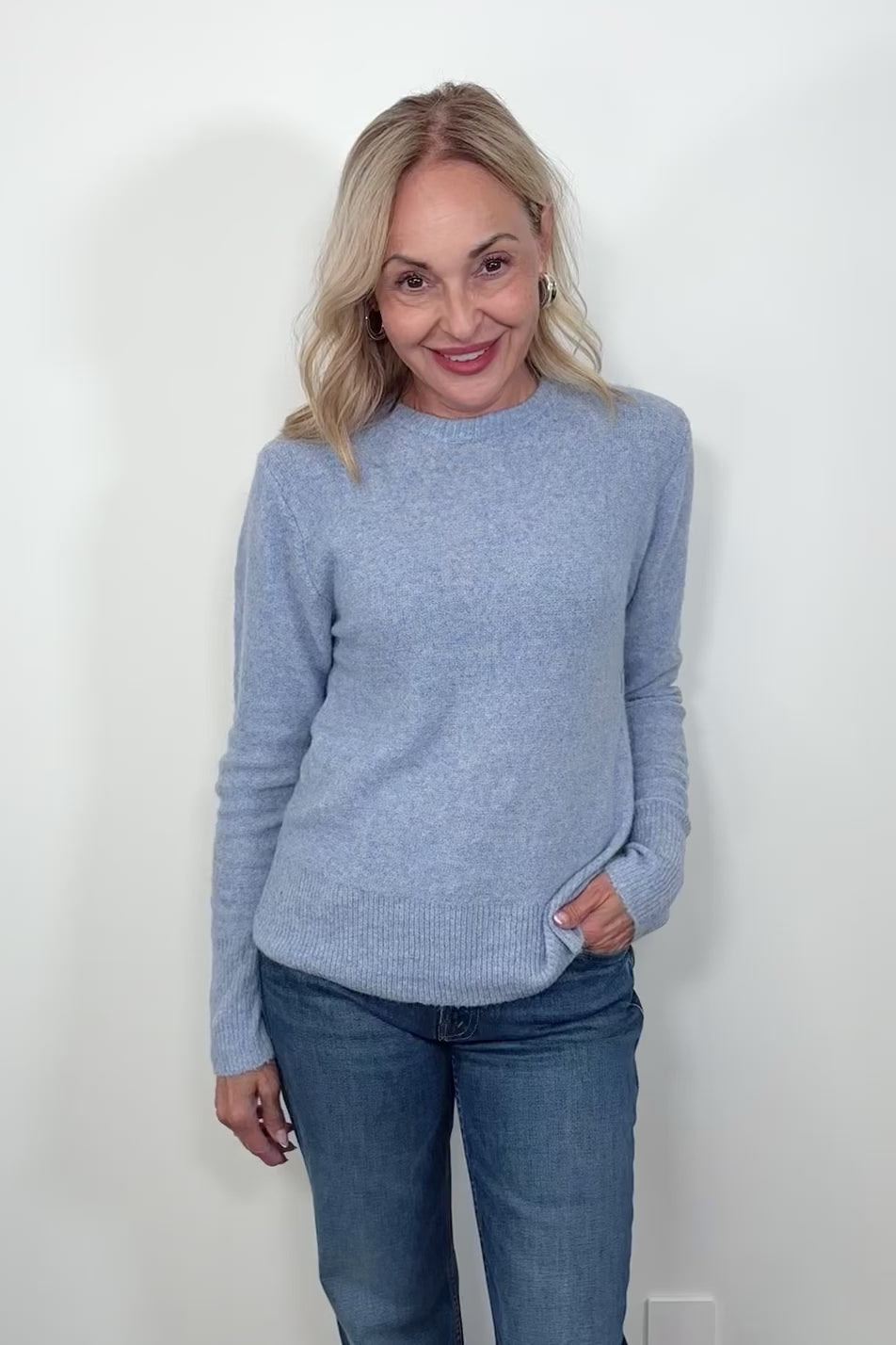 Video of woman wearing a light blue sweater 