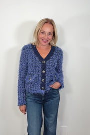 Video of woman wearing a fluffy blue cardigan with front pockets