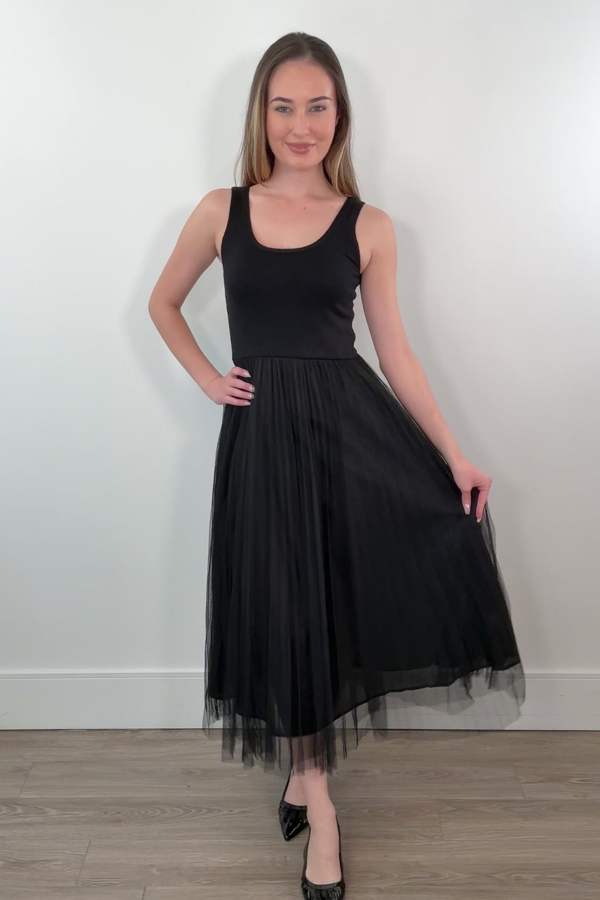video of a woman waring black sleeveless dress with a tulle skirt