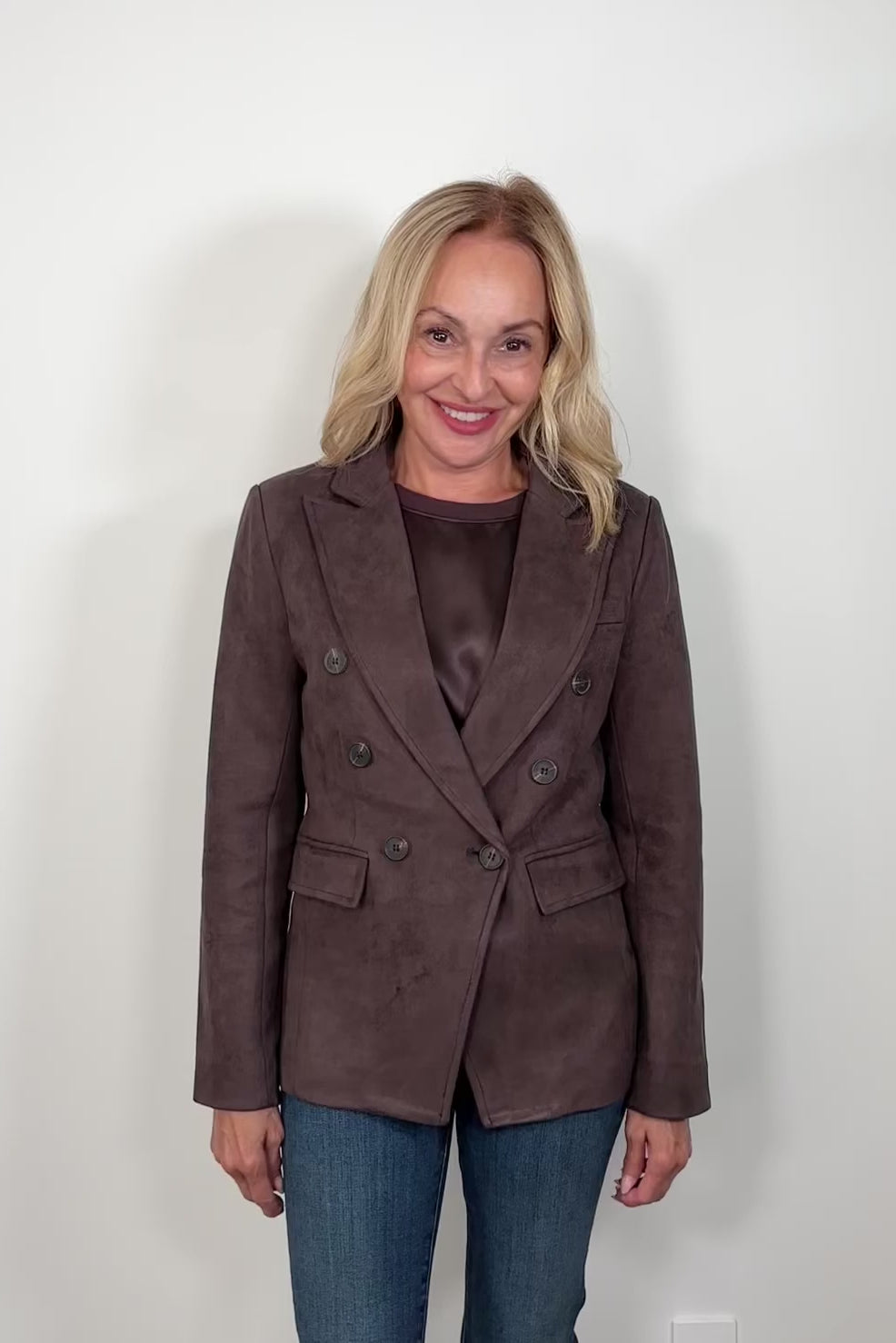 video of a woman wearing a brown satin top with a suede brown blazer closed