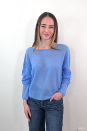 video of a woman wearing blue cashmere sweater with a reversible neckline