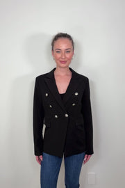Video of woman wearing a black fitted blazer buttoned up