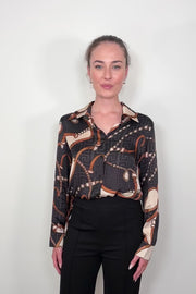 Video of woman wearing a printed button up shirt tucked in